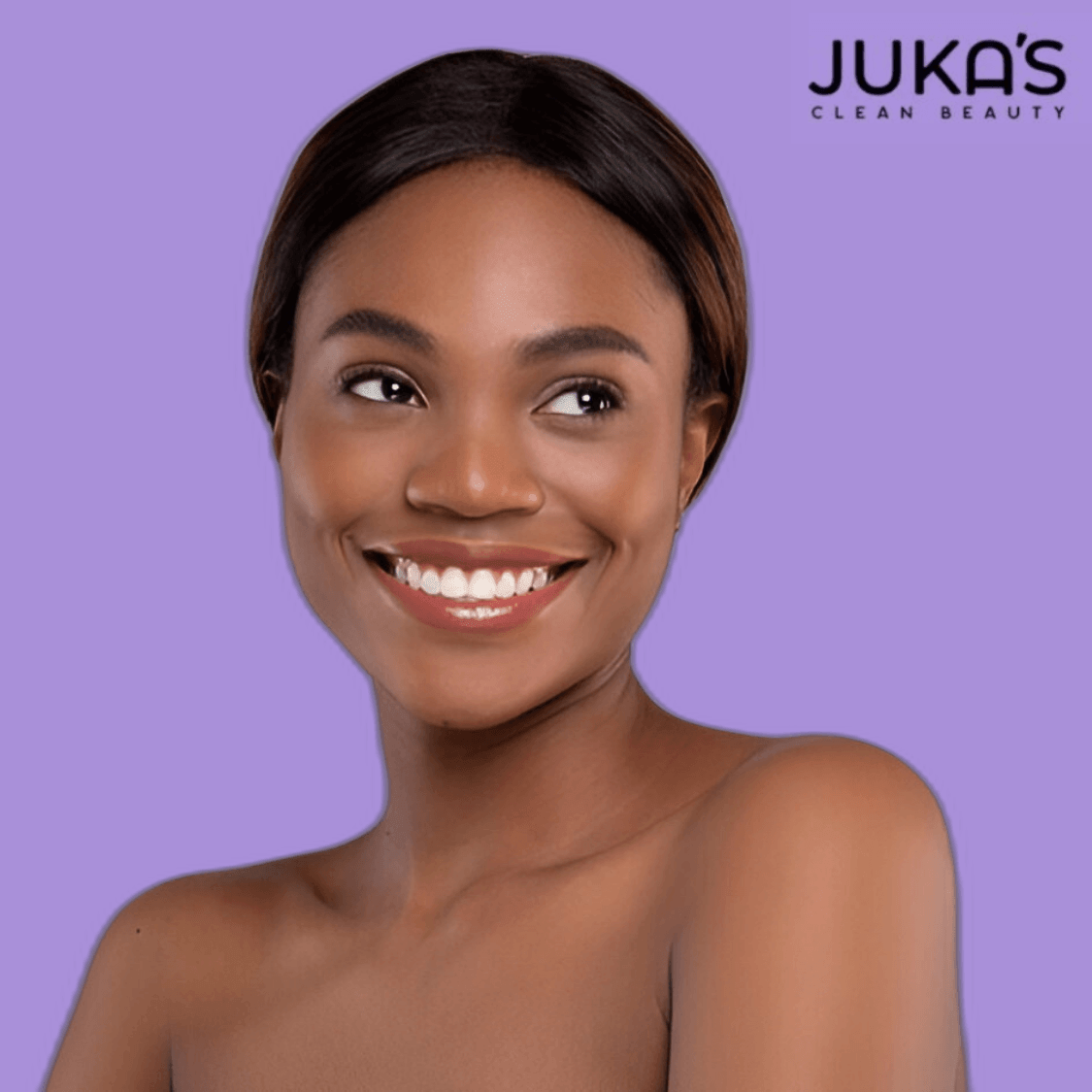 Smiling model showcasing Juka's vegan combination skin care kits on a purple background.