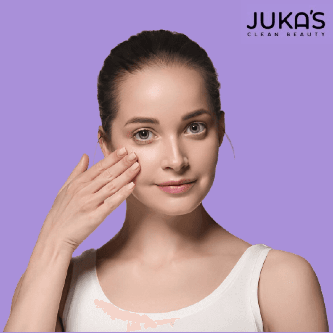 Woman applying Juka's plant-based moisturizer on her face for oily skin.